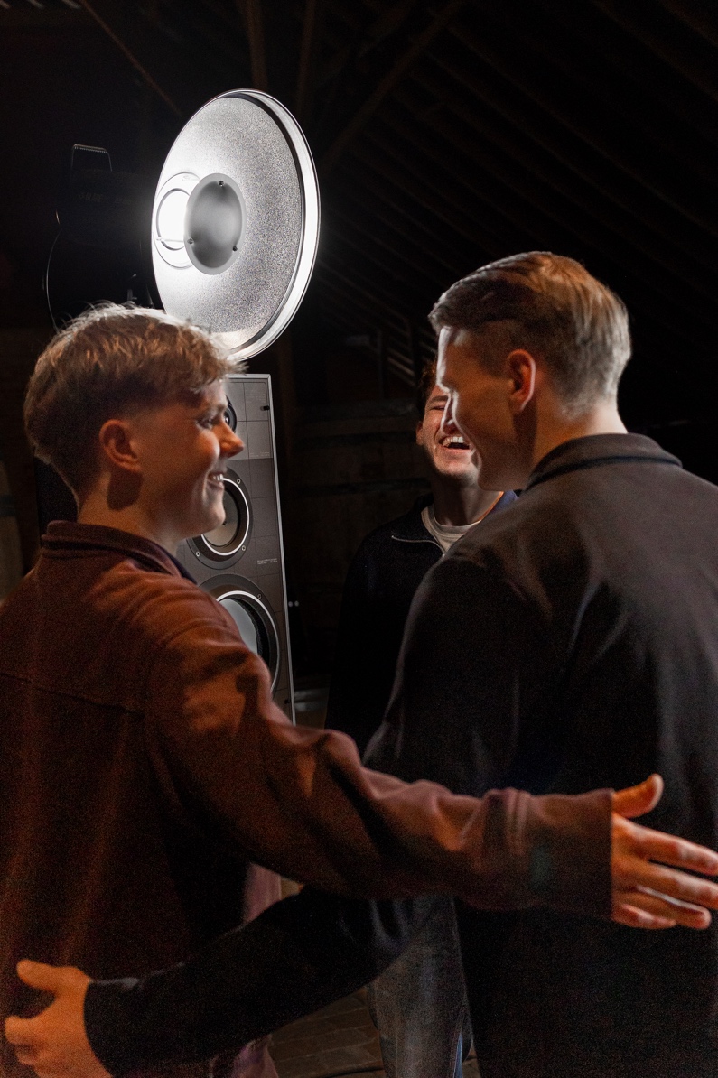 Gasten praten naast THE SPEAKER BOOTH op een sfeervol event